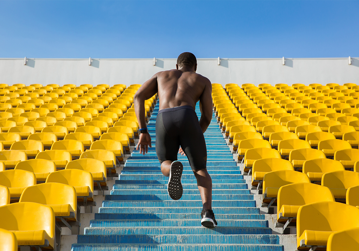 Back view of a sportsman doing speed exercise for muscles